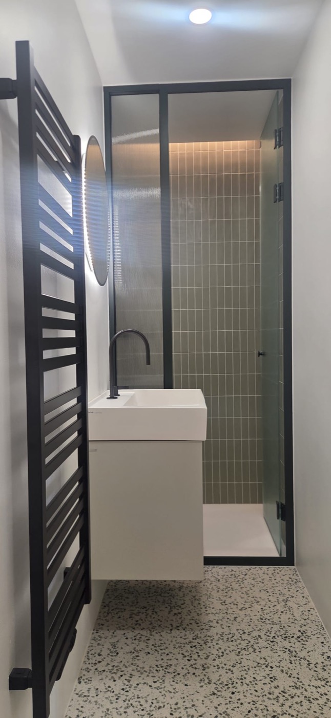 Fertiggestelltes schmales Bad mit Walk-in-Dusche, geriffeltem Glas und schwebendem Waschtisch